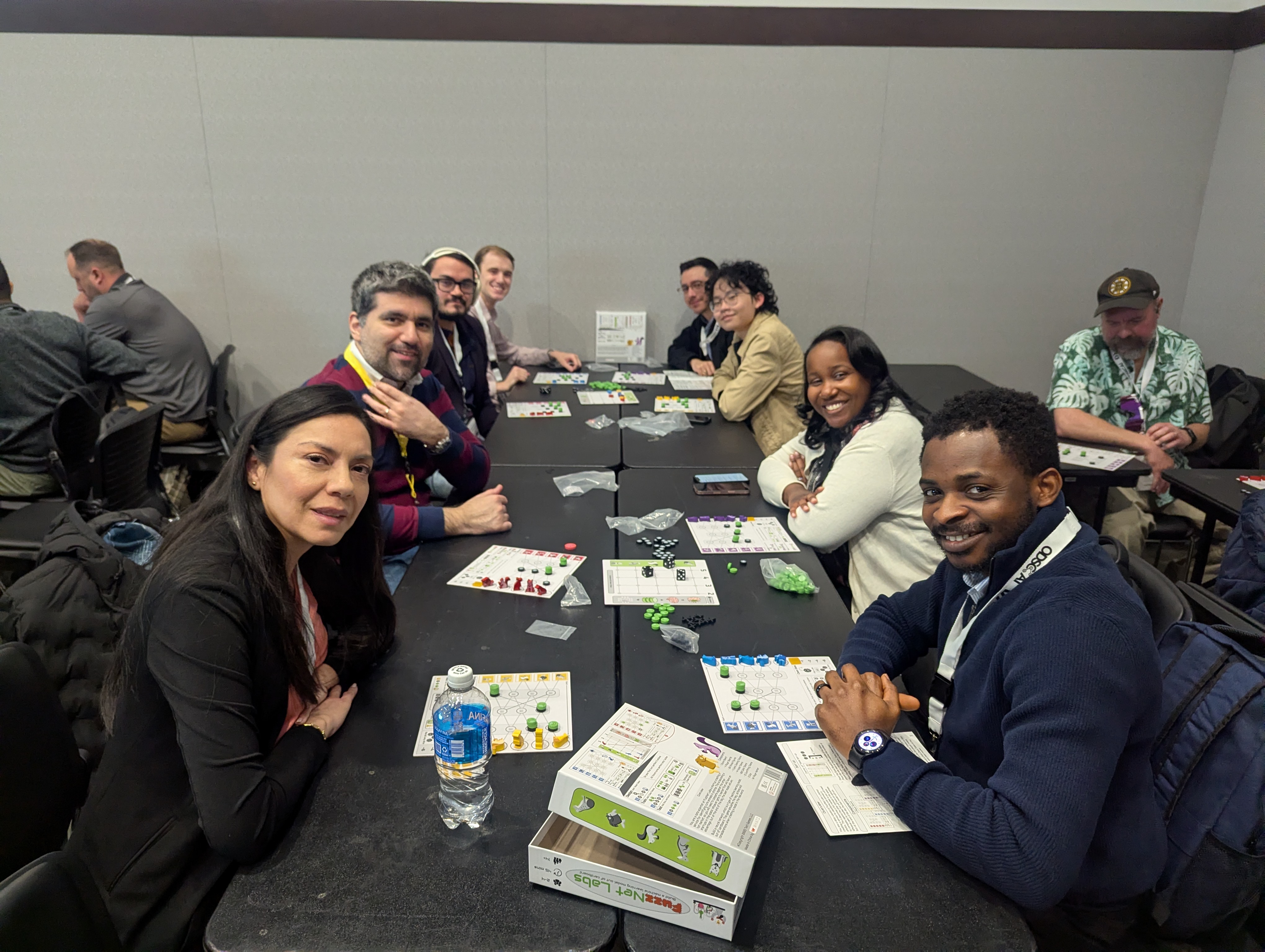 Four participants smiling during a hands-on FuzzNet Labs session around a table